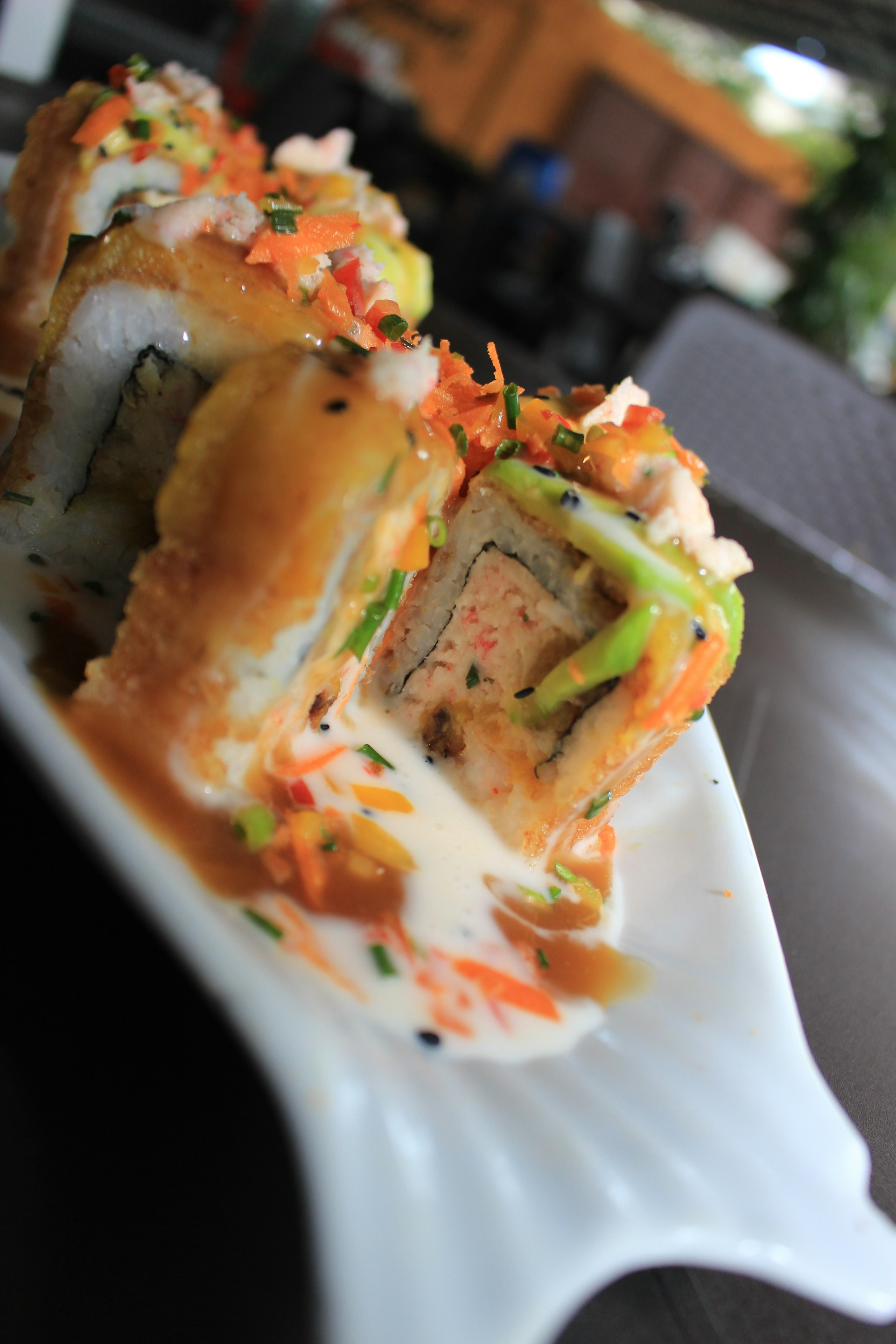 Close-up of colorful makis arranged beautifully on a traditional Japanese plate at Kanagawa Nikkei in Trujillo.