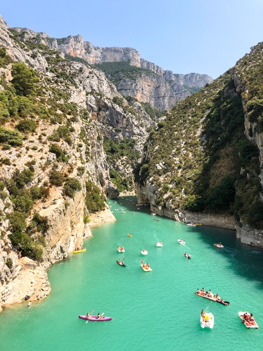 people swimming on river between mountains during daytime in Verdon Natural Regional Park France