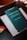 A book with a dark green cover is titled 'Iusnaturalismo y Positivismo Jurídico' by Norberto Bobbio is placed on top of a light-colored folder or book. There are colorful sticky note markers in pink, yellow, green, and blue on a dark surface next to the book.