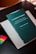A book with a dark green cover is titled 'Iusnaturalismo y Positivismo Jurídico' by Norberto Bobbio is placed on top of a light-colored folder or book. There are colorful sticky note markers in pink, yellow, green, and blue on a dark surface next to the book.