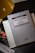 A book titled 'Teoría General del Derecho' by Norberto Bobbio is placed on a dark surface next to a desk lamp. The book appears to be a fifth edition from Editor Temis. A small toy soldier, a colorful bookmark, and a folded white notebook are also visible in the scene.
