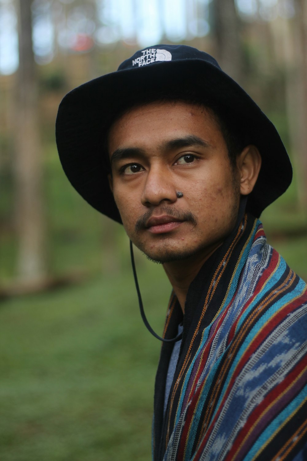 man in black hat and red blue and white plaid shirt