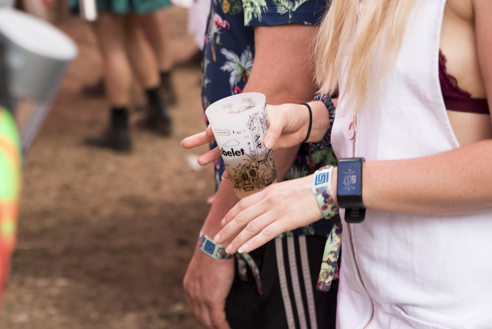 woman in white long sleeve shirt holding starbucks cup