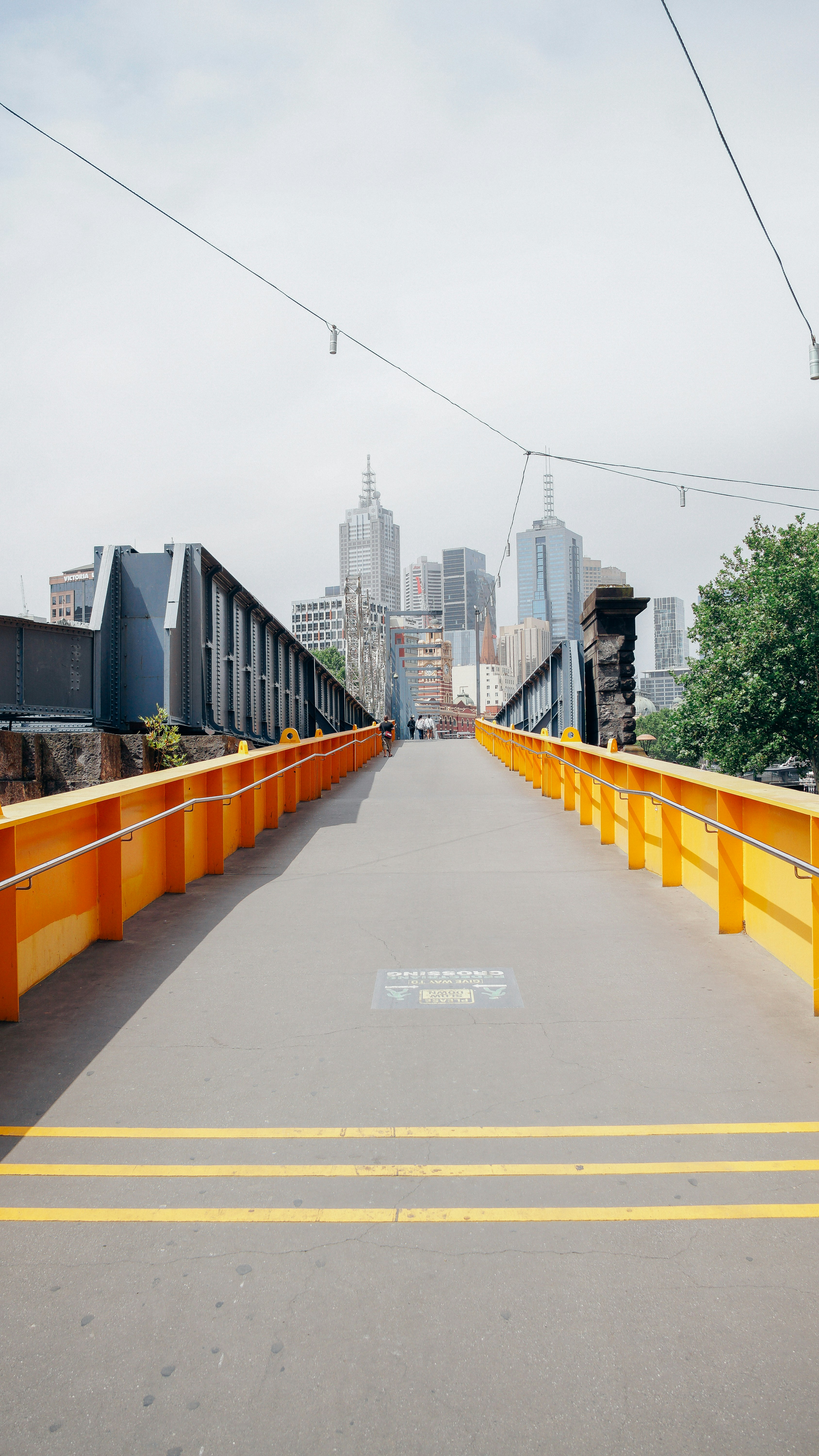 昼間の黒い金属フェンスの間の灰色のコンクリートの通路