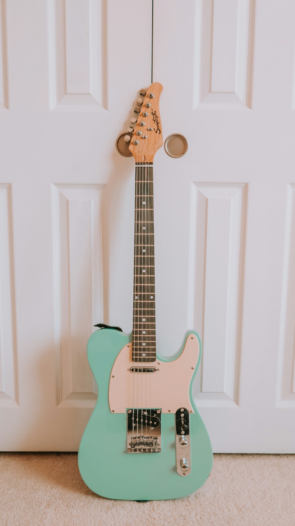 white and brown stratocaster electric guitar