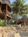 Image of a beachside resort with open-air wooden structures blending into the coastal landscape.