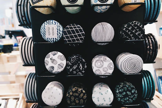 Shiny metal buttons with intricate designs displayed on a rustic wooden surface.