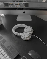 A serene workspace with sheet music, headphones, and a laptop showing a music production software.