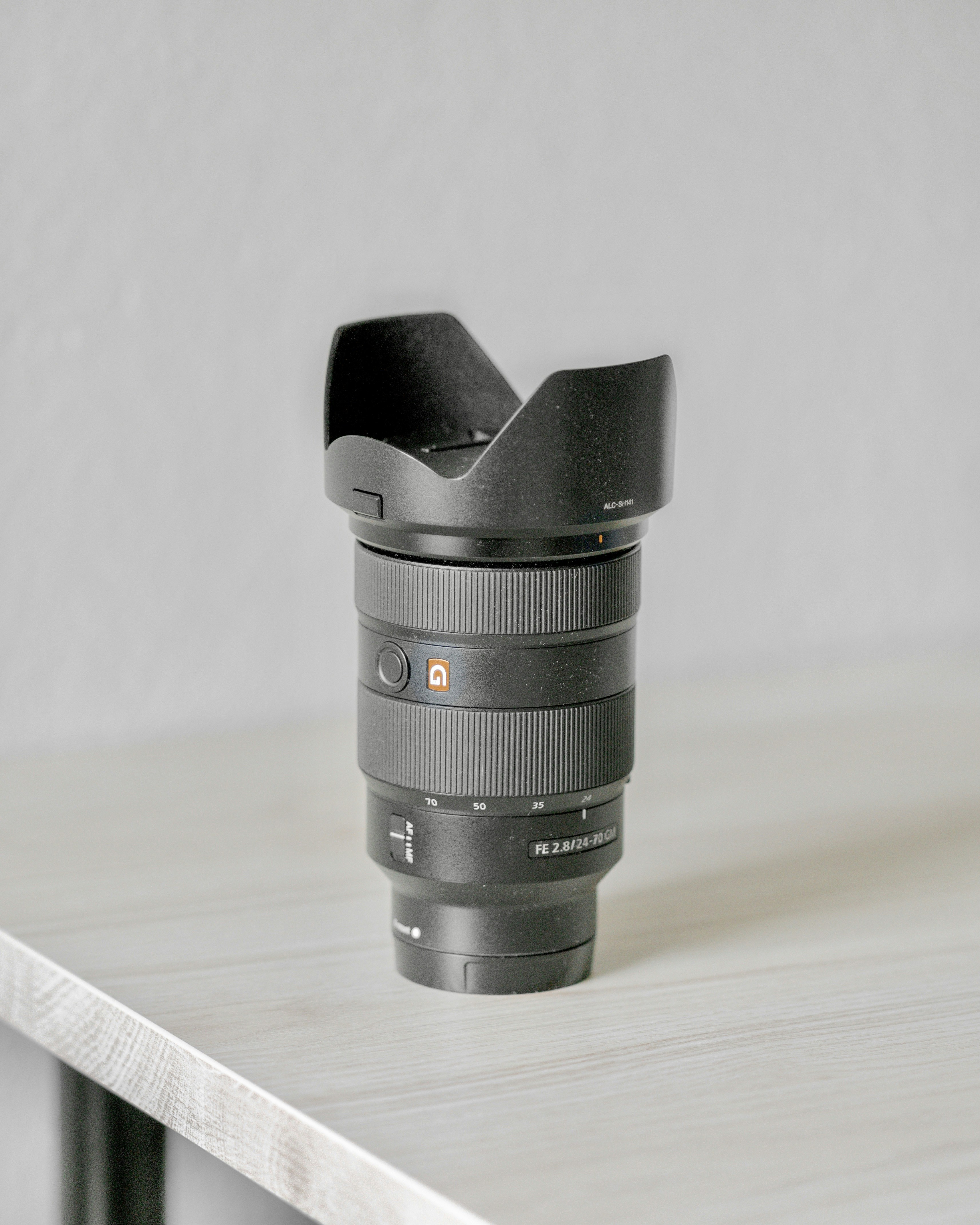 schwarzes Kameraobjektiv auf braunem Holztisch