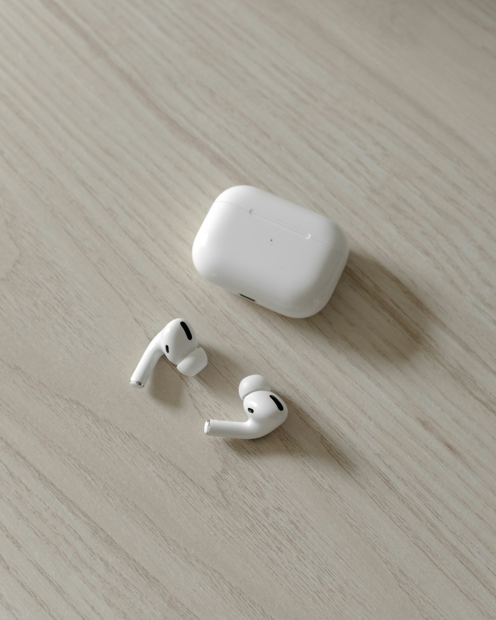 white apple airpods on brown wooden table