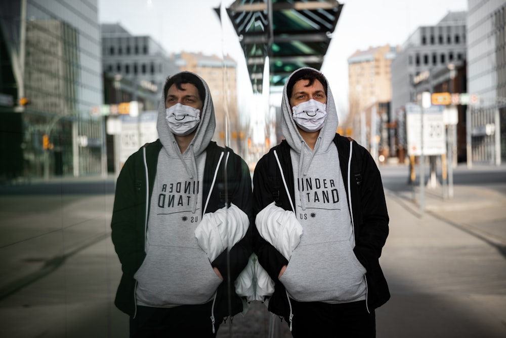 2 women in gray and black hoodie standing on gray concrete floor during daytime