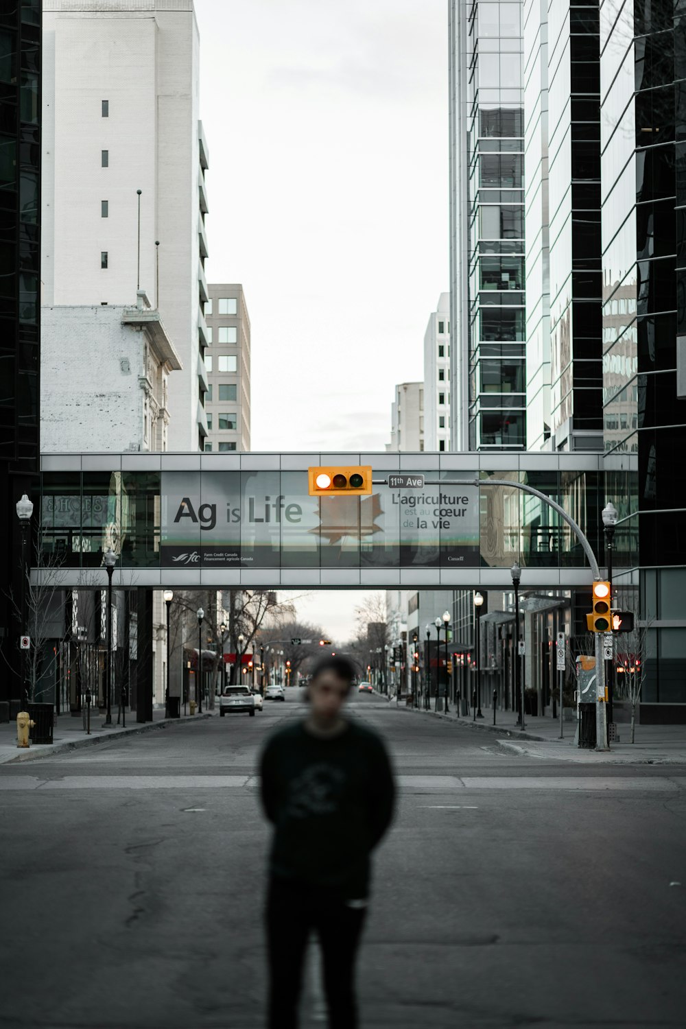 man in black jacket standing on pedestrian lane during daytime