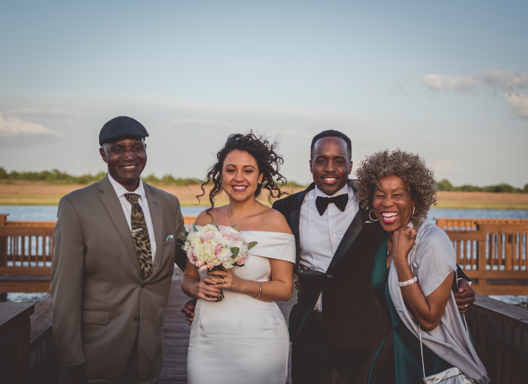 man in black suit jacket beside woman in white dress holding bouquet of flowers