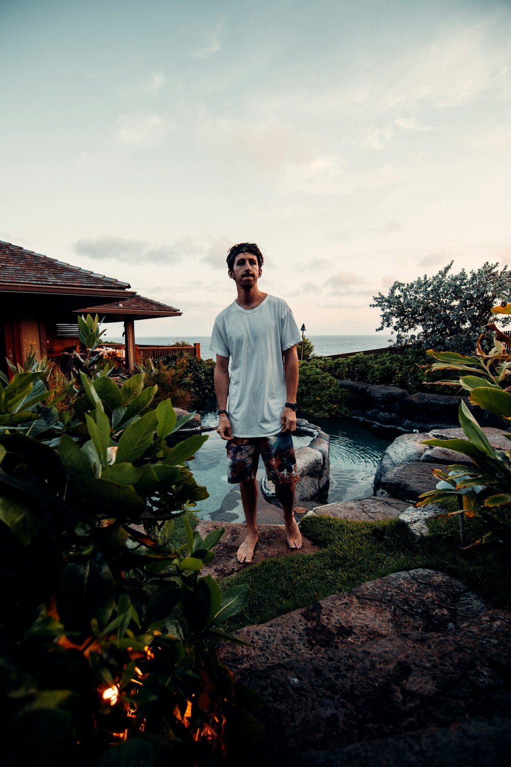 man in white crew neck t-shirt standing on rocky shore during daytime