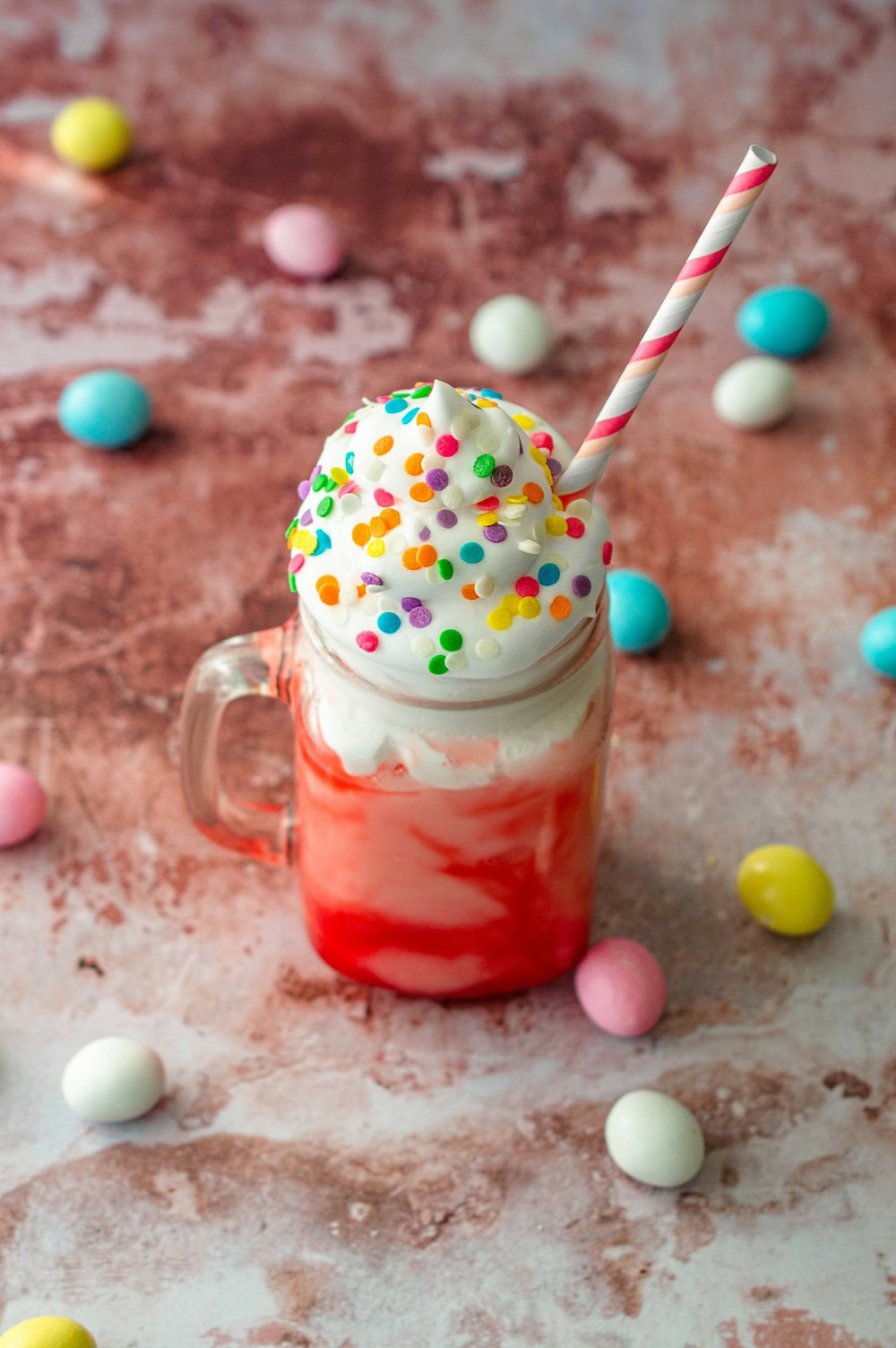 clear glass mug with red liquid and white and red straw