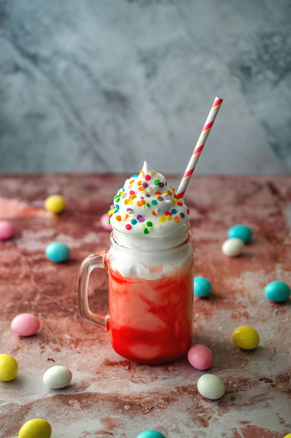 clear glass mug with red liquid and white straw