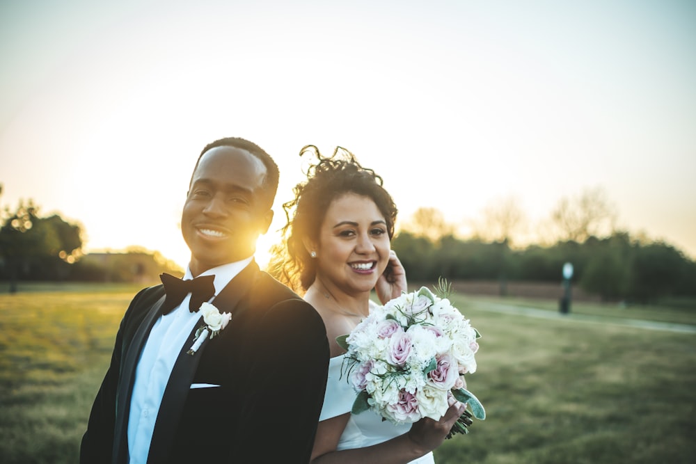 man and woman holding bouquet of flowers