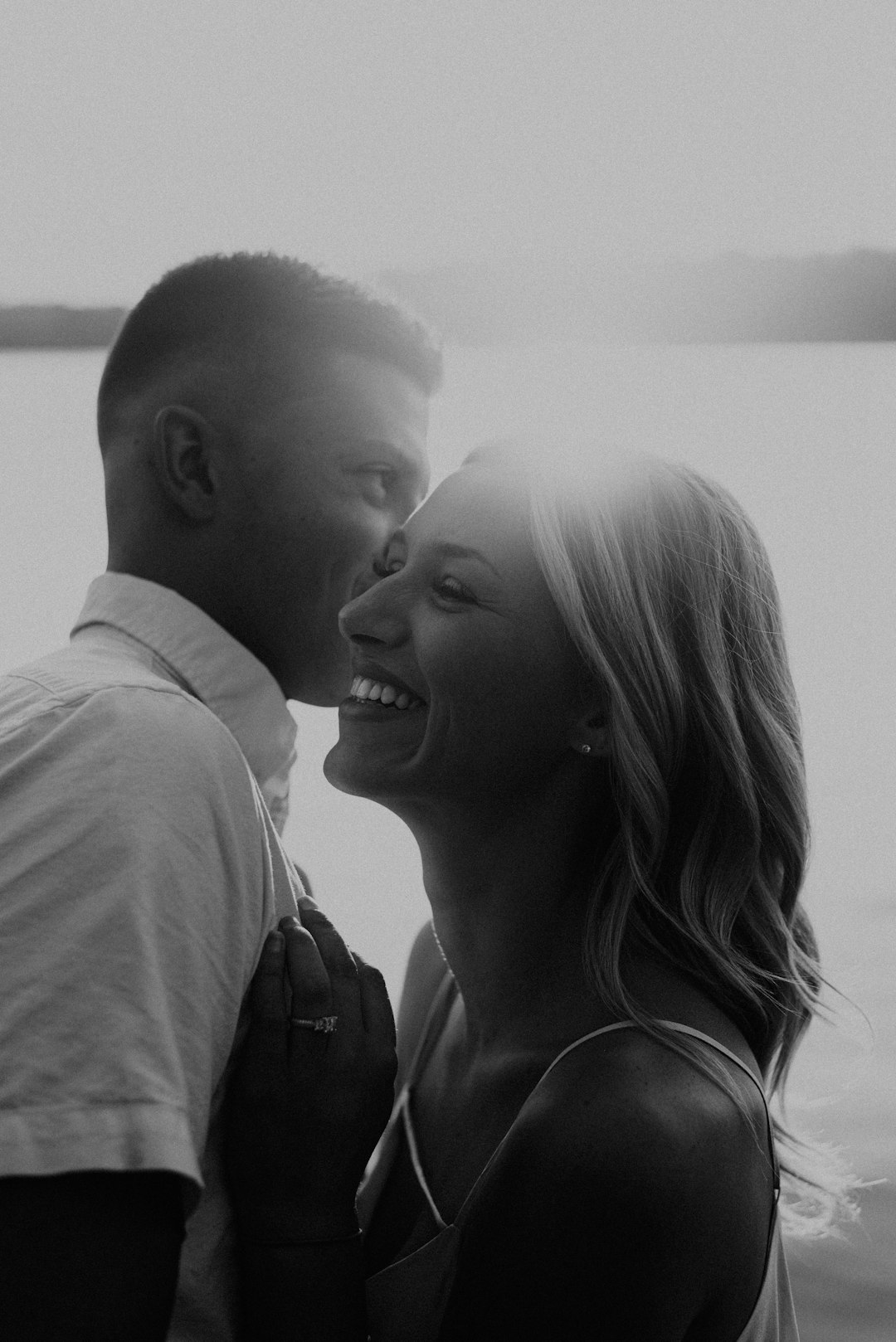 man and woman smiling in grayscale photography