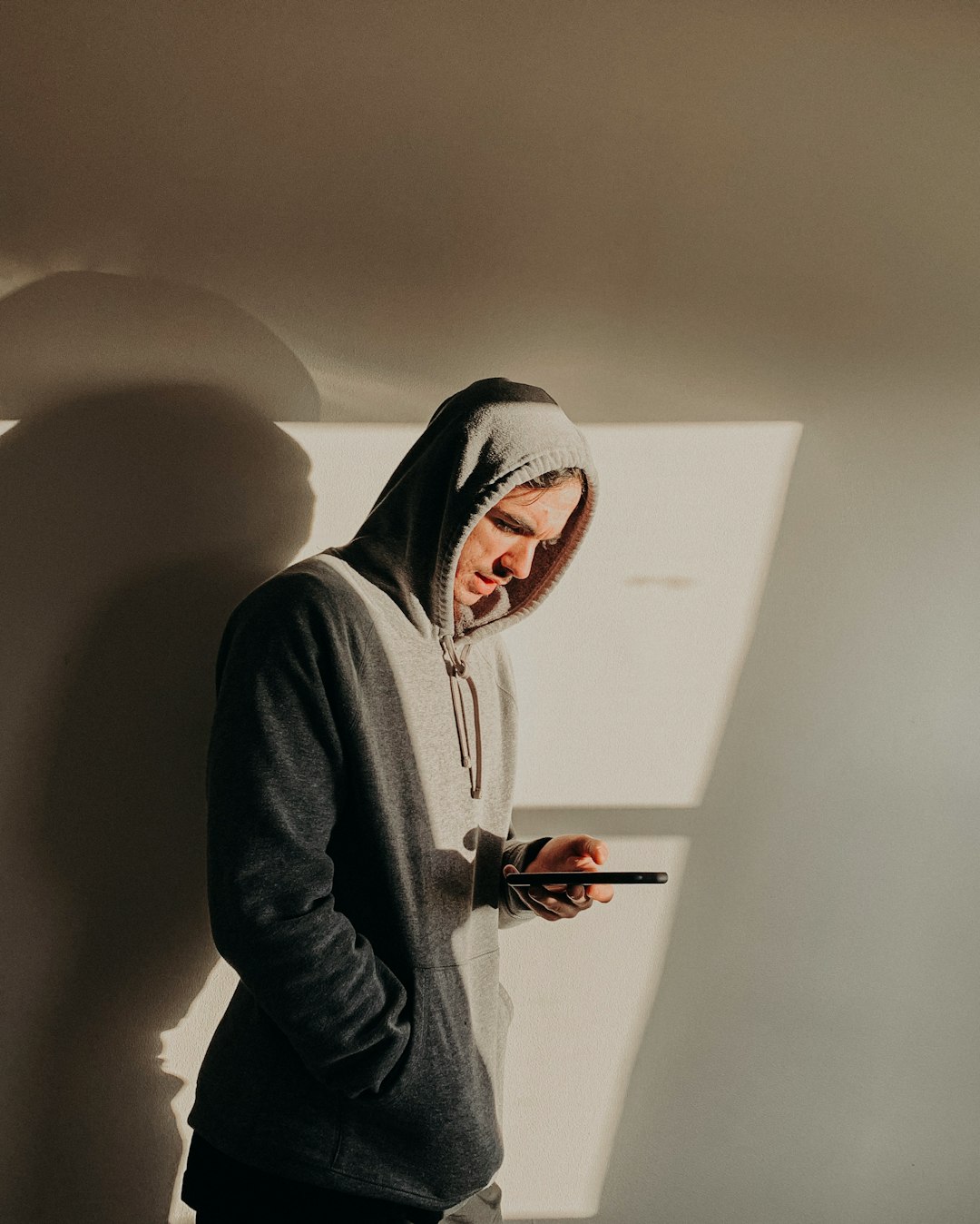 man in gray hoodie holding red and black toy gun