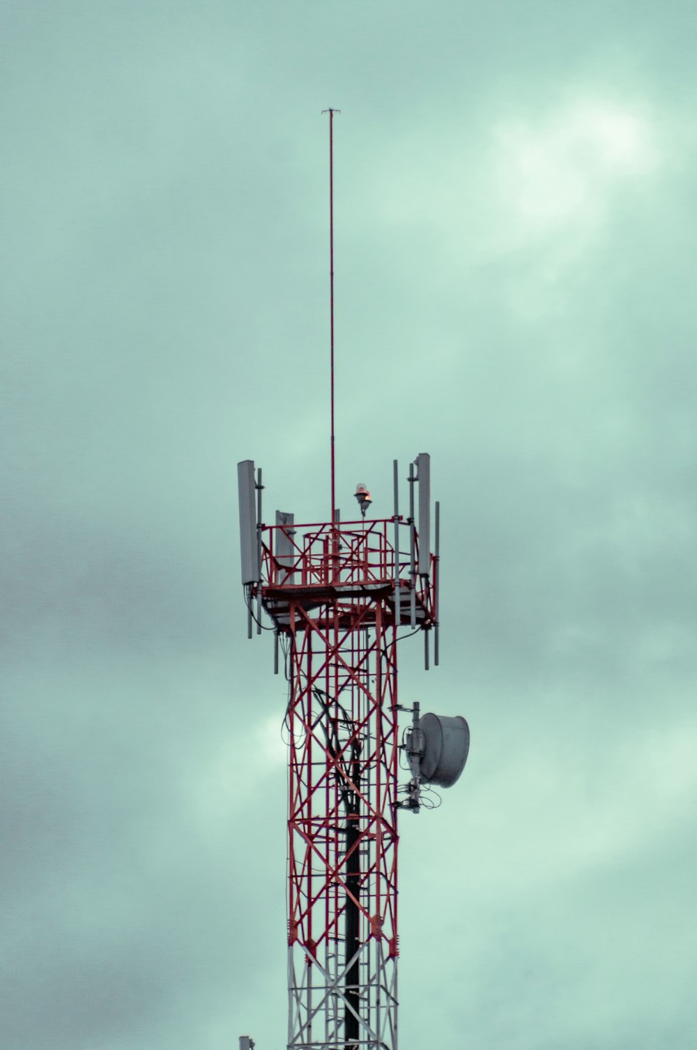 red and black metal tower under gray clouds