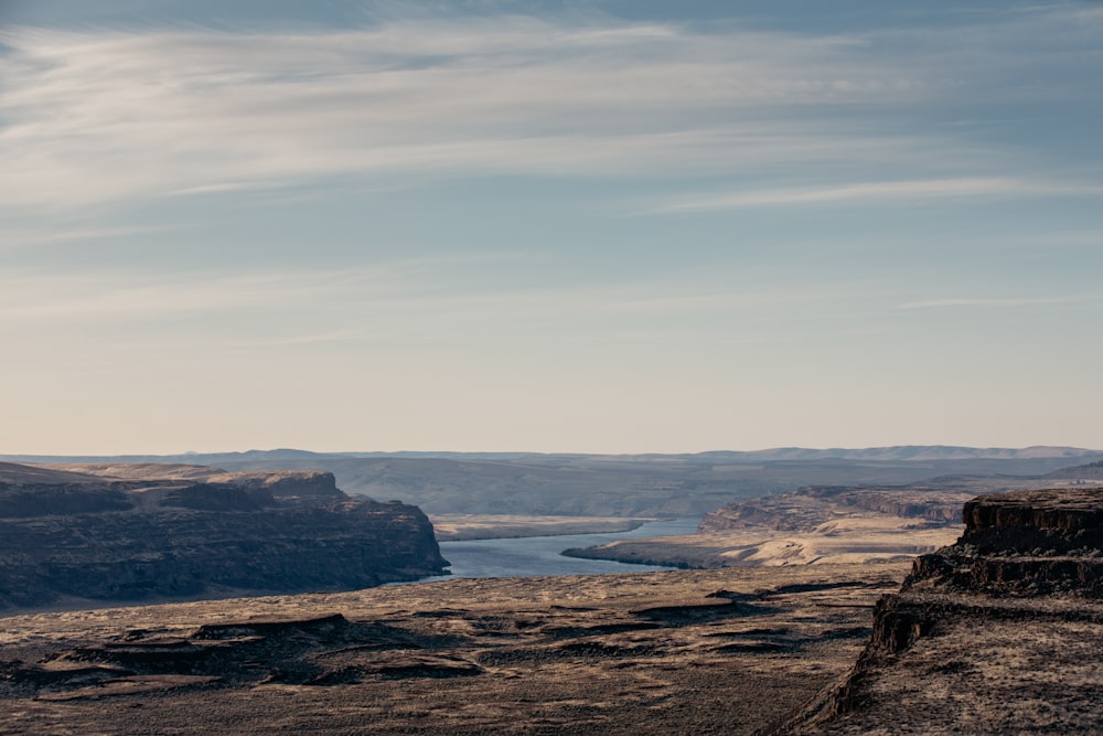 brown and green mountain beside body of water during daytime