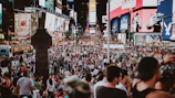 A panoramic view of a lively city square filled with tourists and street performers.