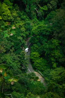 An Inova Reborn vehicle driving along a winding road in Bandung's highlands.