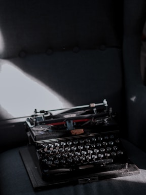 A dimly lit vintage typewriter with a shadowy figure in the background, evoking suspense.