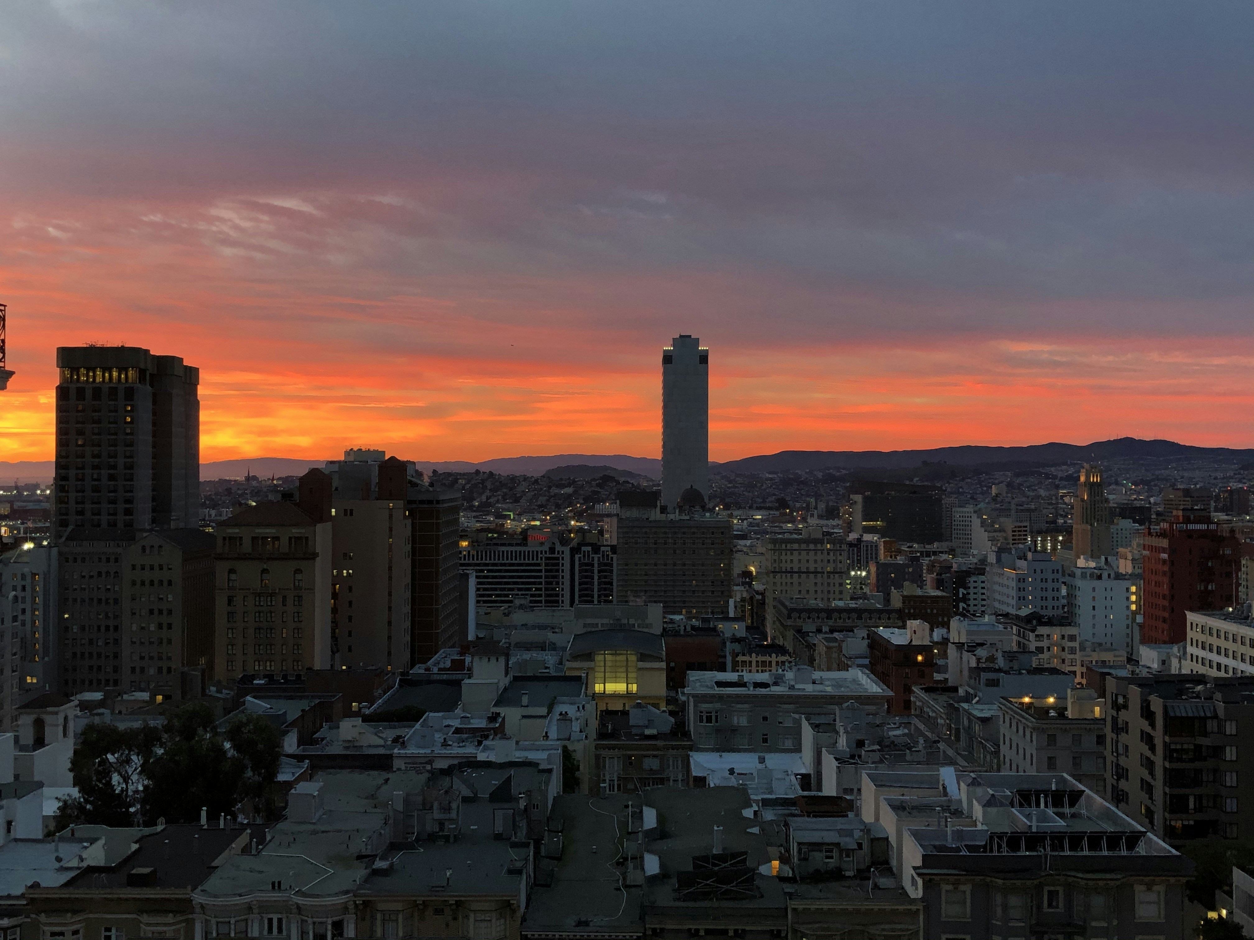 a sunset view of a city with tall buildings