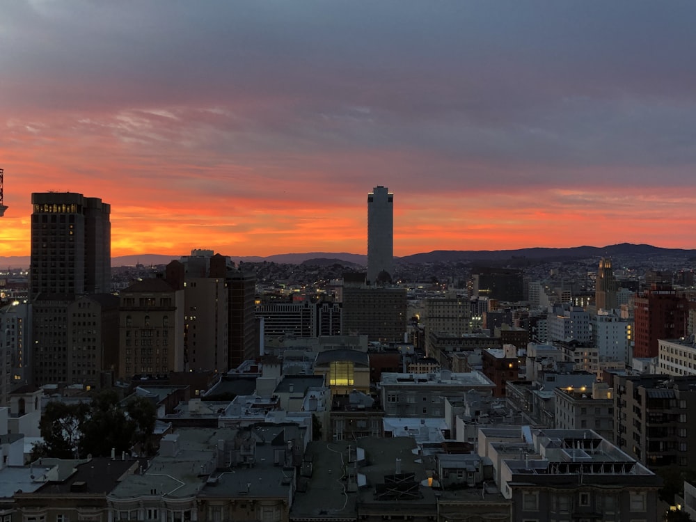 a sunset view of a city with tall buildings