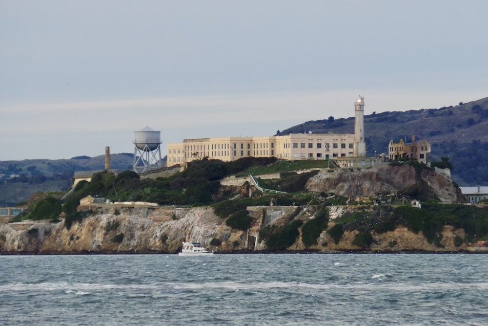 a large building sitting on top of a hill next to a body of water