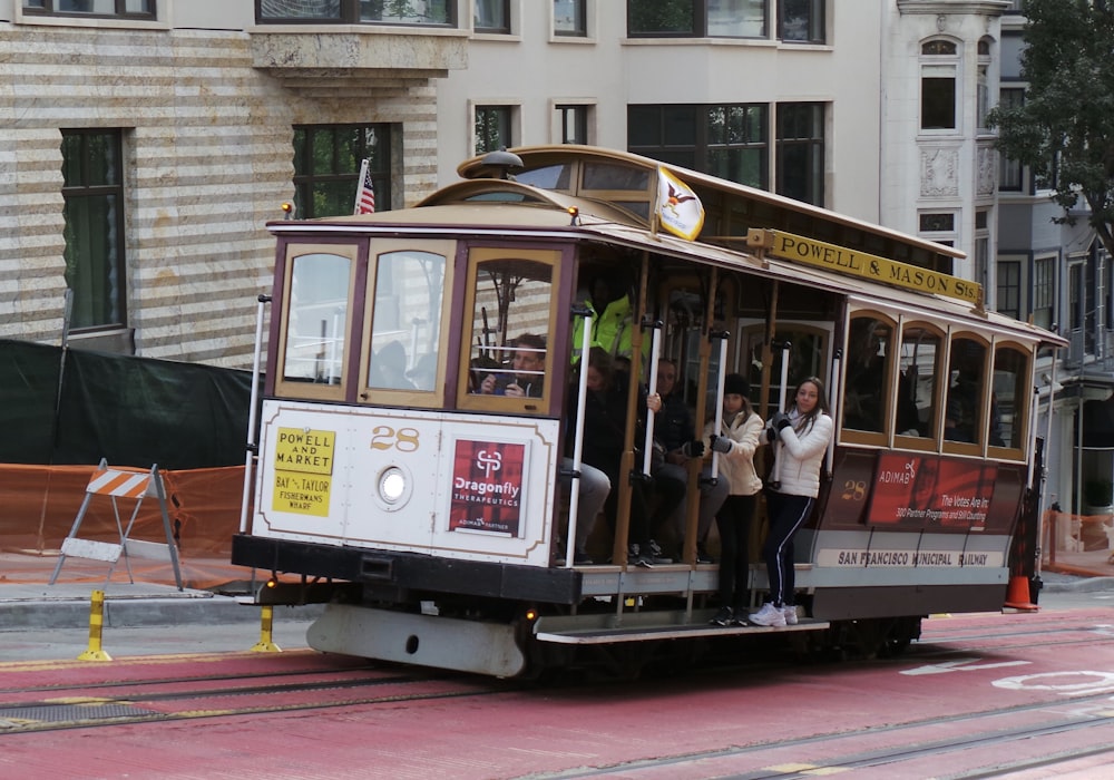 people riding on white and red tram during daytime