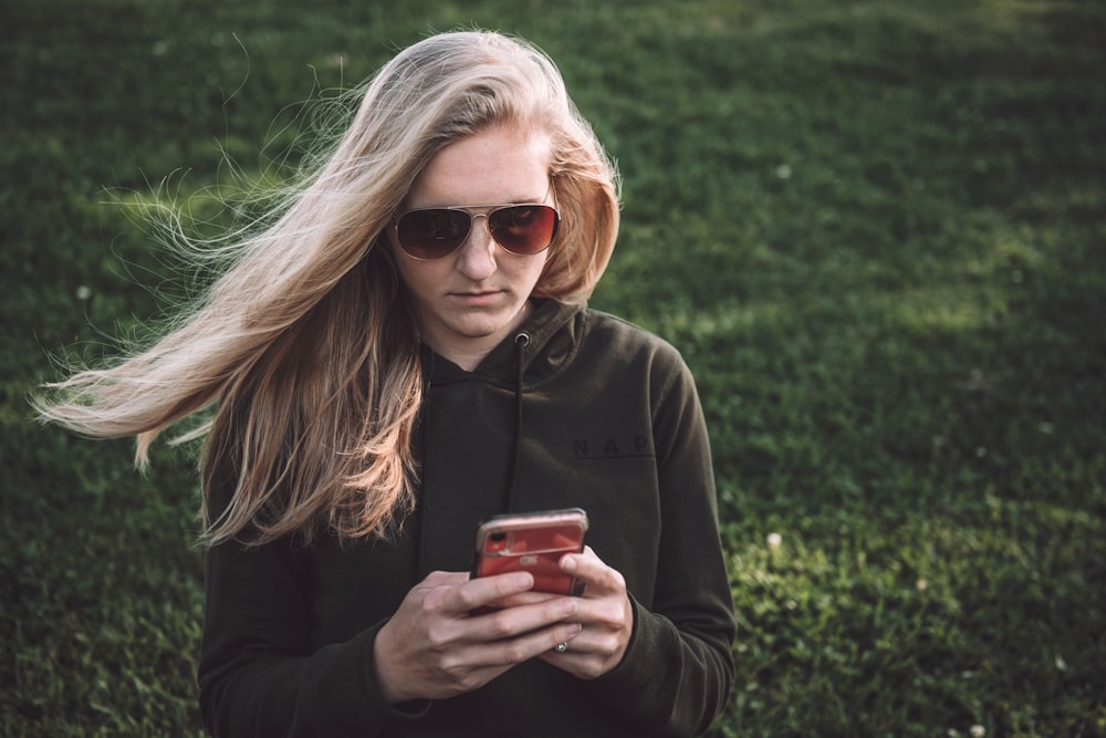 woman in black leather jacket holding red ceramic mug