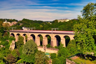 brown concrete bridge over river under cloudy sky during daytime