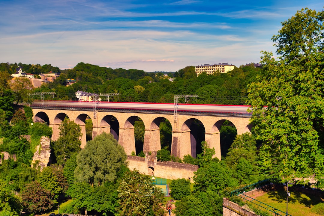 brown concrete bridge over river under cloudy sky during daytime