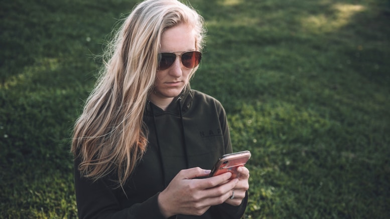 woman in black jacket holding smartphone