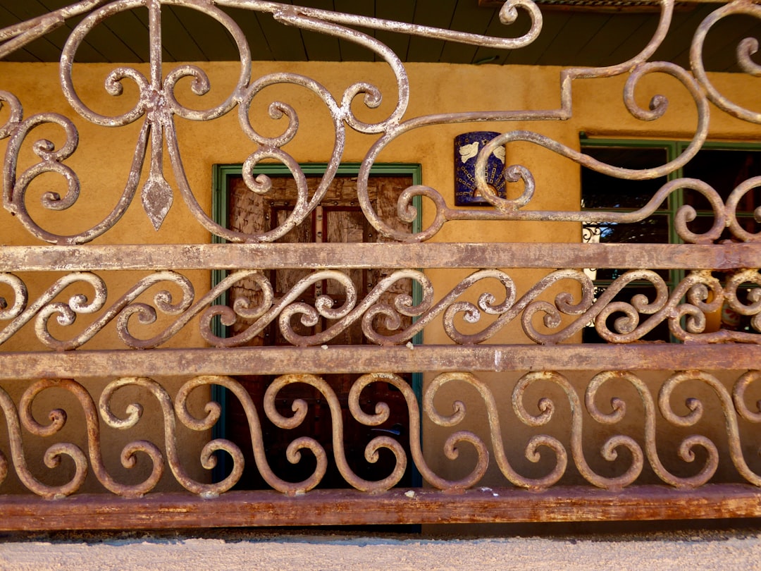 black metal fence on brown wooden wall,