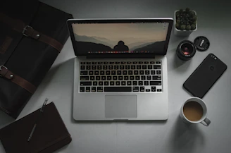 macbook pro beside brown leather wallet