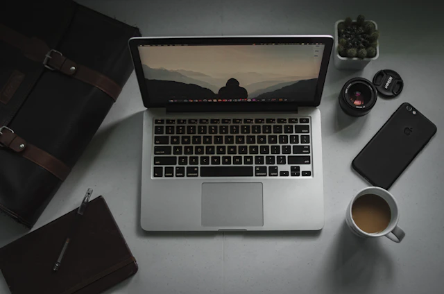 macbook pro beside brown leather wallet