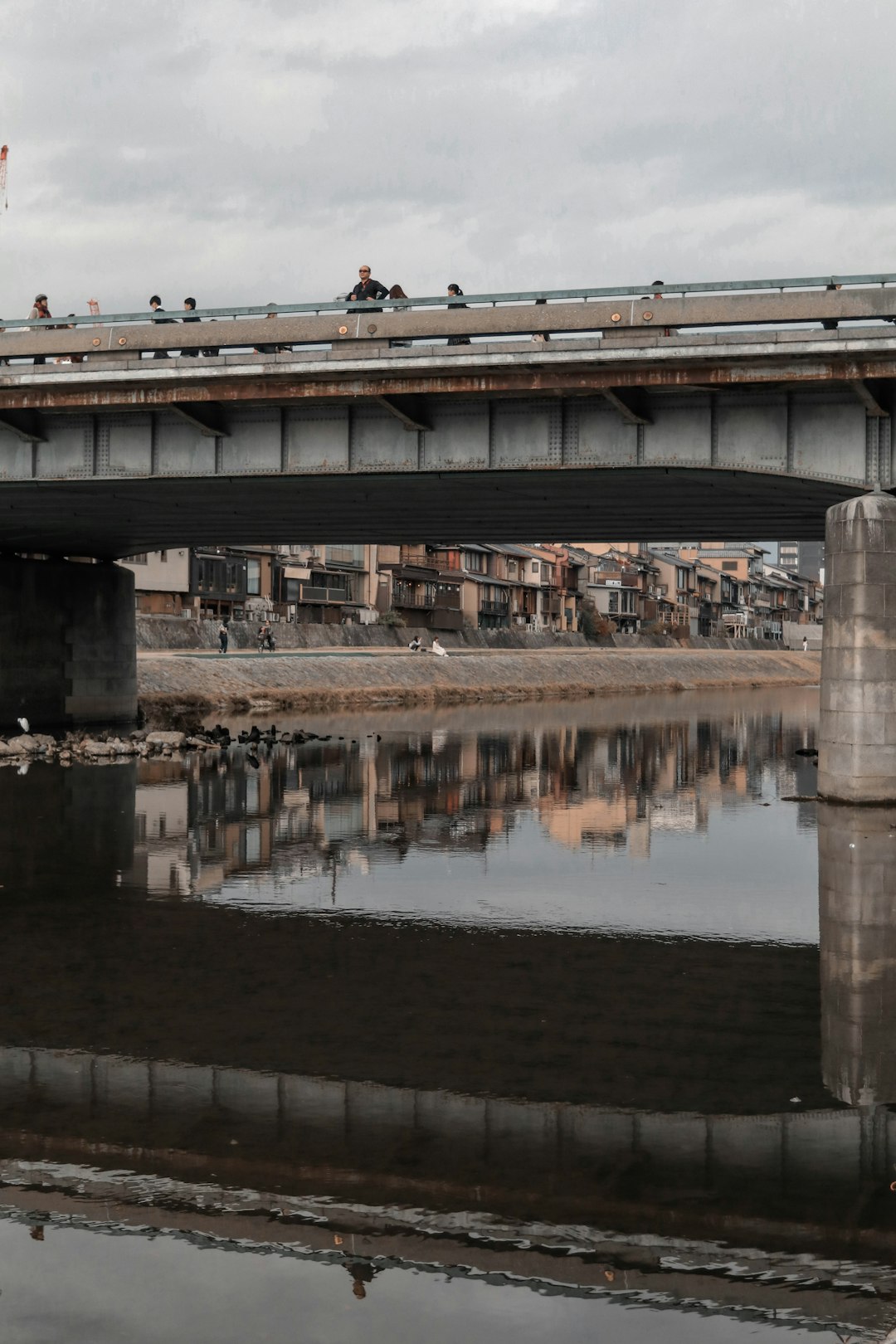 people walking on bridge over river during daytime