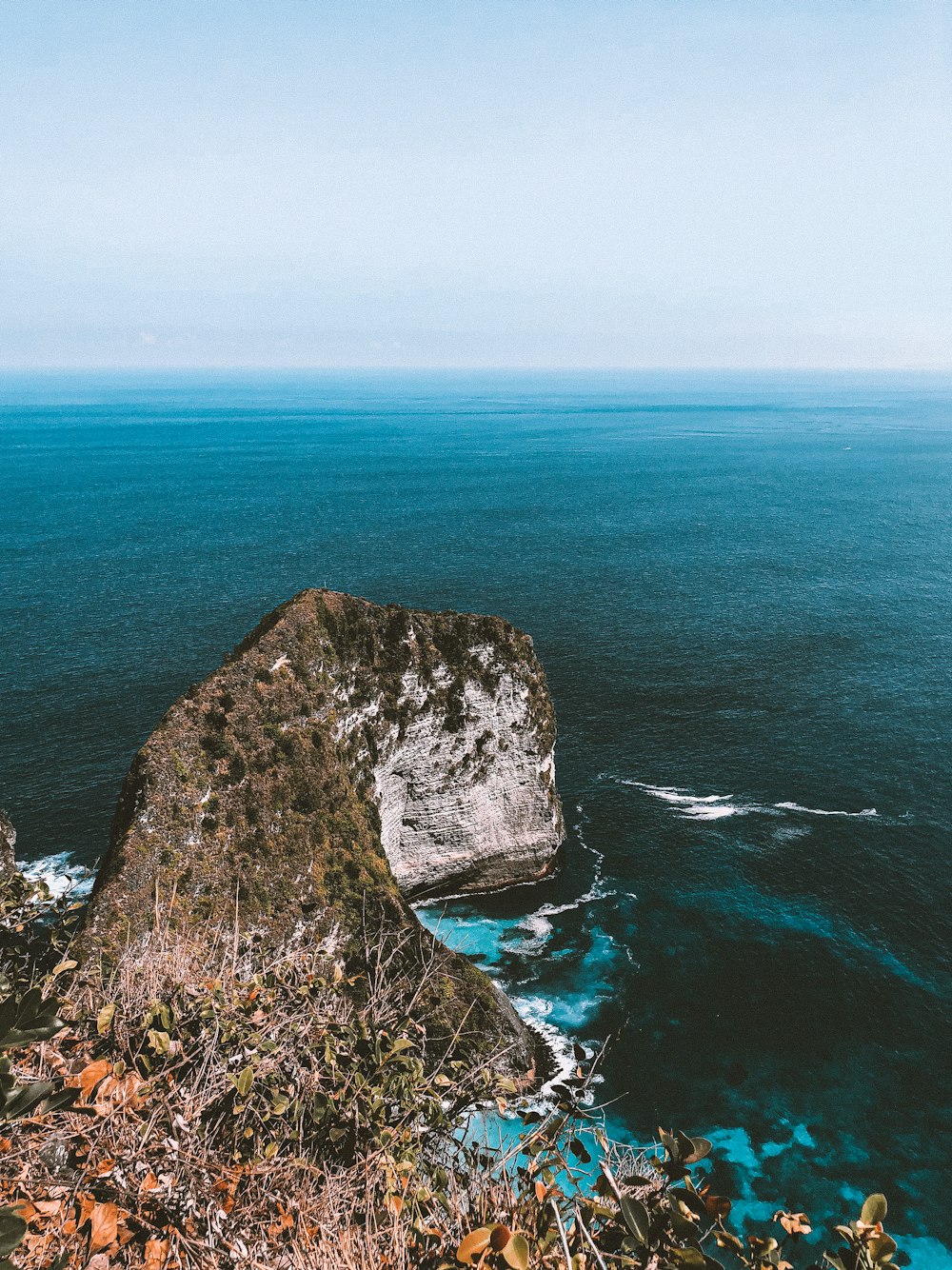 gray rock formation beside body of water during daytime