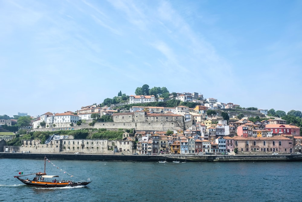 boat on water near city buildings during daytime