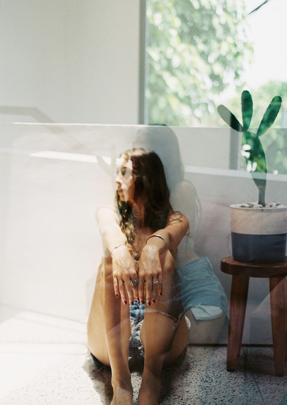 woman in blue denim shorts sitting on brown wooden chair