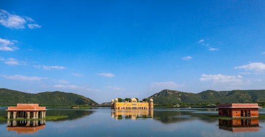 brown concrete building near body of water under blue sky during daytime in Rajasthan India