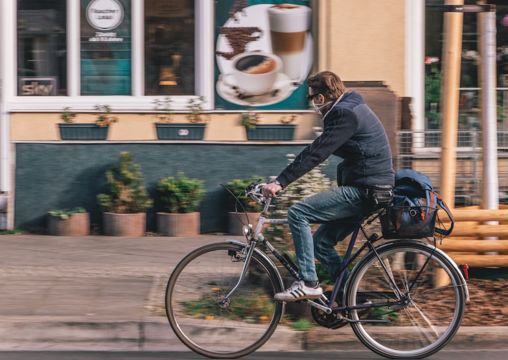 woman in black jacket riding on black bicycle during daytime