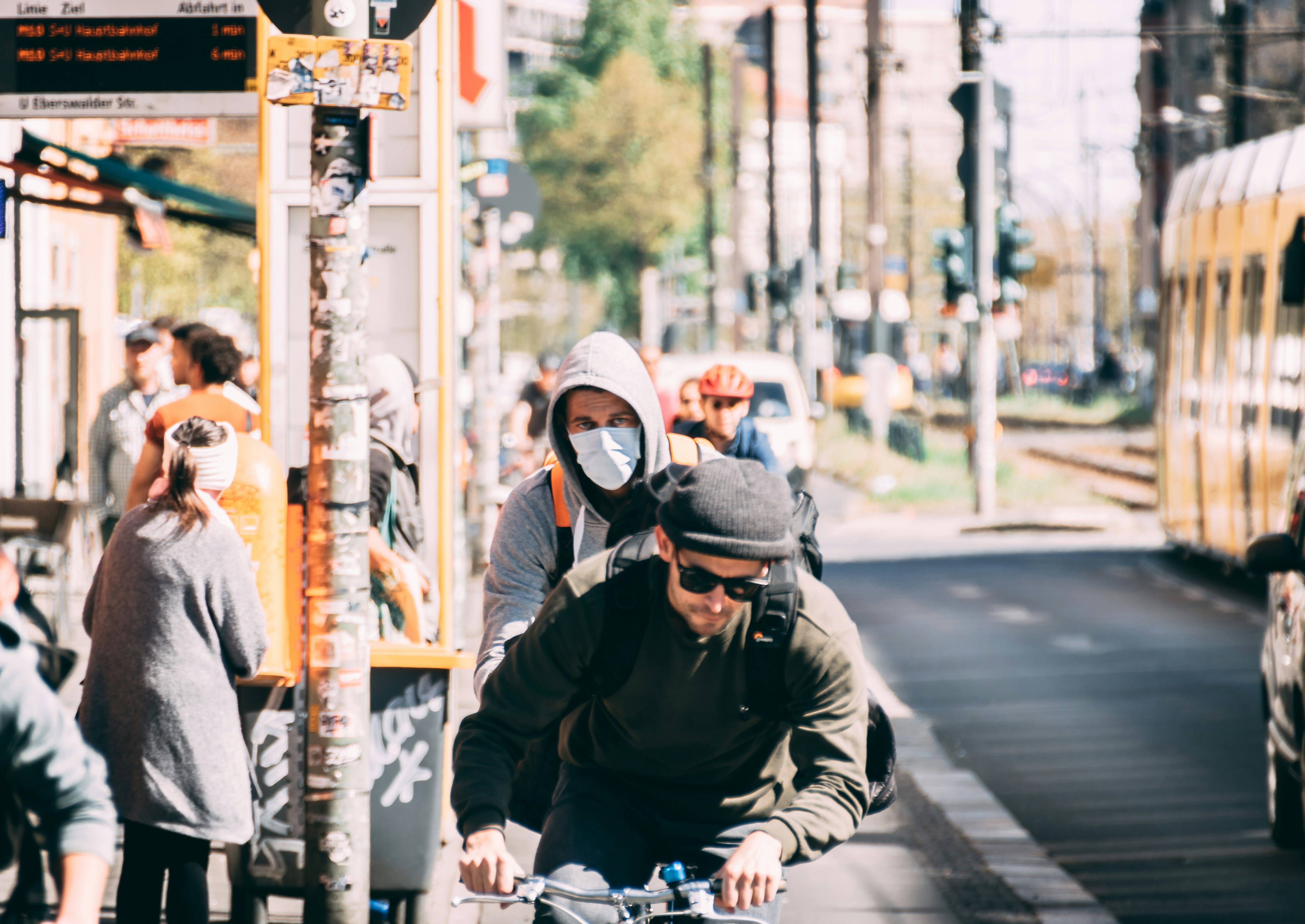 A man riding a bicycle wearing a mask