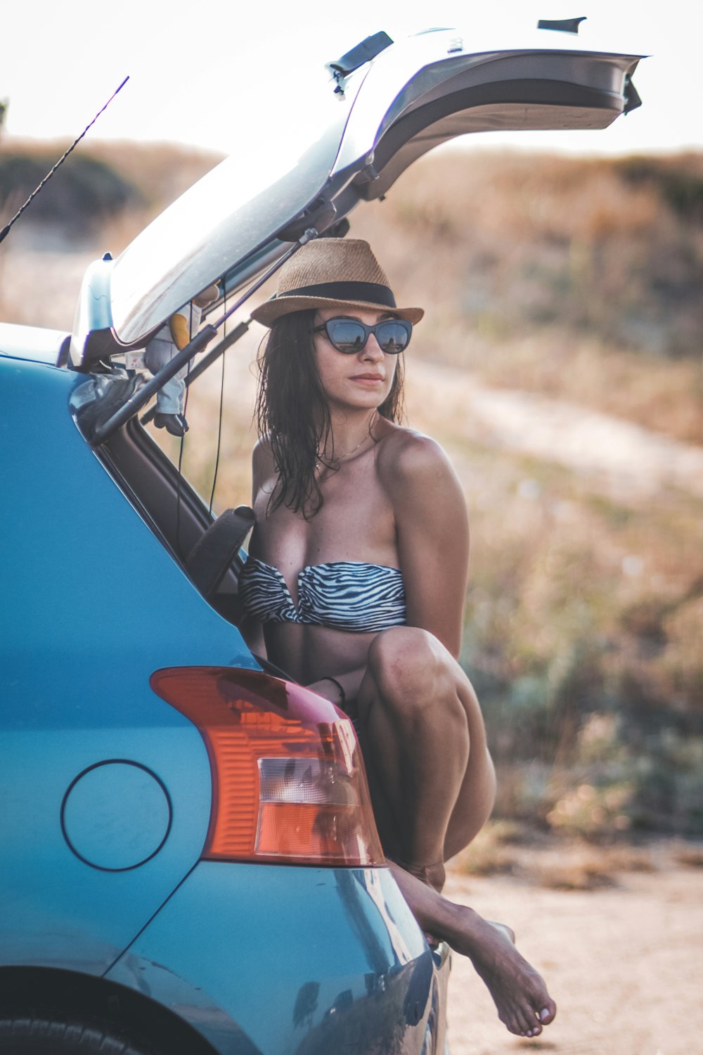 woman in black bikini lying on white and black boat during daytime