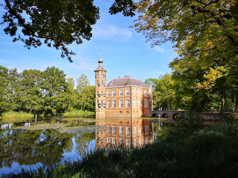 brown concrete building near green trees and river during daytime