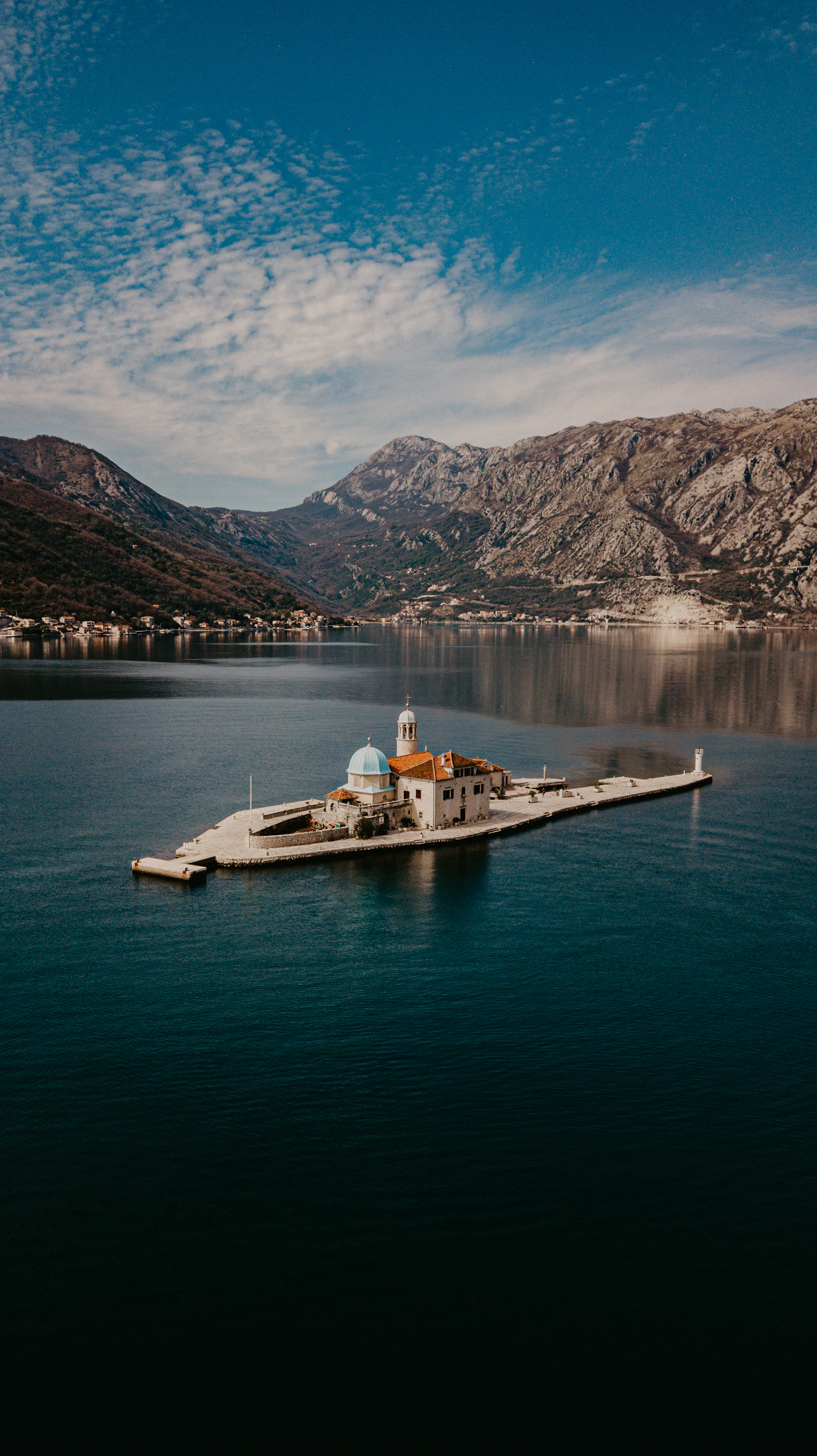 Calm Adriatic water below steep coastal mountains in Montenegro