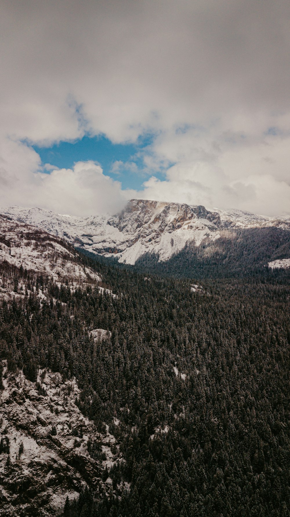 snow covered mountain under cloudy sky during daytime